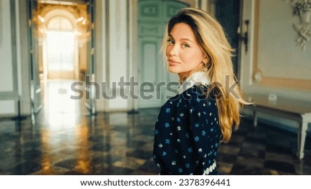 Portrait of attractive caucasian woman in black dress in medieval castle turns back and looking on camera, victorian vintage interior  Royalty-Free Stock Photo #2378396441