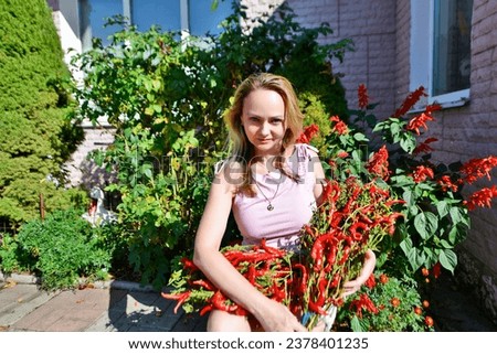 Autumn photo shoot of a beautiful woman with a bouquet of red peppers.