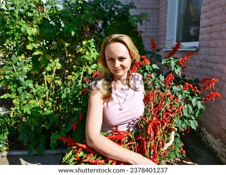 Autumn photo shoot of a beautiful woman with a bouquet of red peppers.