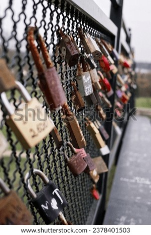 Lots of padlocks on the railing of the footbridge. Padlocks symbolizing love relationships.