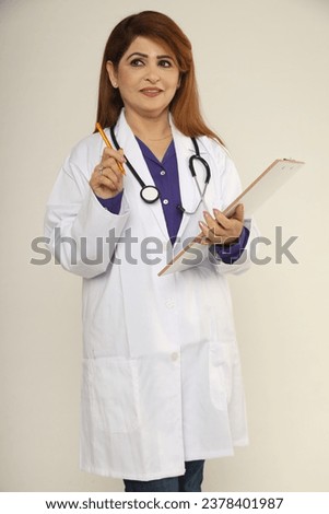 Indian female doctor with white medical coat, stethoscope look at camera. Indian woman health care professional medical posing while standing on studio background., portrait. Asian healthcare concepts