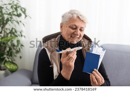 old woman holding Passport, boarding pass and toy airplane