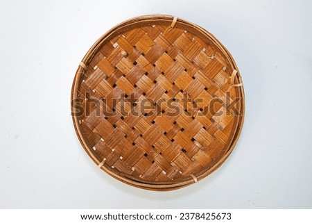 Traditional woven plate made of bamboo or woven bamboo plate basket isolated on white background. Royalty-Free Stock Photo #2378425673