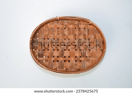 Traditional woven plate made of bamboo or woven bamboo plate basket isolated on white background. Royalty-Free Stock Photo #2378425675