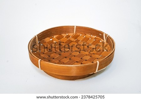 Traditional woven plate made of bamboo or woven bamboo plate basket isolated on white background. Royalty-Free Stock Photo #2378425705