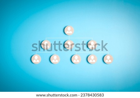 Vertical organization chart, or organigram. Wooden blocks with people icons on a blue background. Human resources career path, employees leveling hierarchy table. People team structure tree diagram. Royalty-Free Stock Photo #2378430583