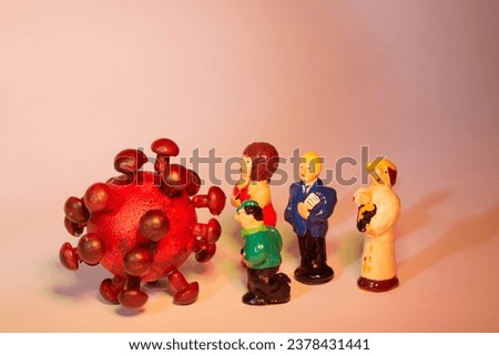 model of a virus and figurines as symbol for danger of infection by corona virus