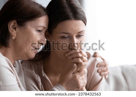 Loving worried mature mom comforting sad adult daughter faces close up, understanding old mum consoling encourages crying upset grown up child being friend helps with problem, shares heartache concept Royalty-Free Stock Photo #2378432563
