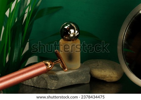 High frequency rejuvenating facial massager T-Vibe and serum bottle. Face and neck lifting massagers and a glass bottle of oil, essential water for body care on stone podium Dark key beauty photo.