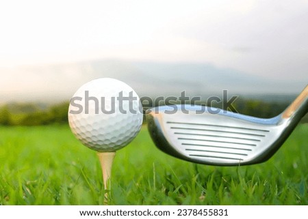 Picture of a golf ball set on a tee and club head 1, a long-distance golf equipment. There is a mountain in the background.
