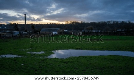 puddle on the grass. Puddle of water on the grass at the horse farm after the rain. sunset cloudy landscape