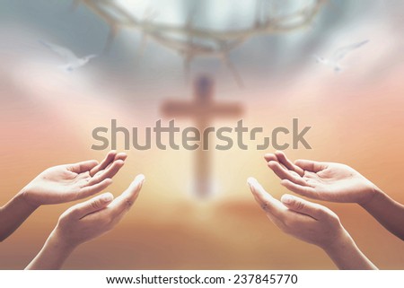 Ascension day concept: Jesus Christ hands over blurred cross and crown of thorn background 