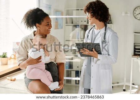 Pediatrician talking to mom during her visit Royalty-Free Stock Photo #2378465863