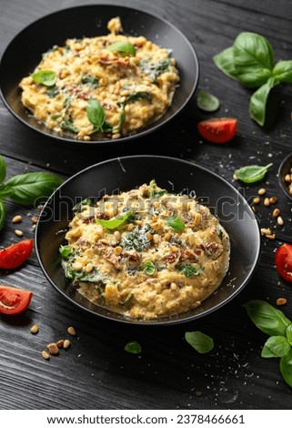 Creamy spaghetti squash pasta with parmesan cheese and sun dried tomato sauce served with pine nuts and basil. Royalty-Free Stock Photo #2378466661