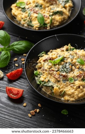 Creamy spaghetti squash pasta with parmesan cheese and sun dried tomato sauce served with pine nuts and basil. Royalty-Free Stock Photo #2378466663
