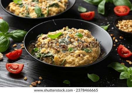 Creamy spaghetti squash pasta with parmesan cheese and sun dried tomato sauce served with pine nuts and basil. Royalty-Free Stock Photo #2378466665