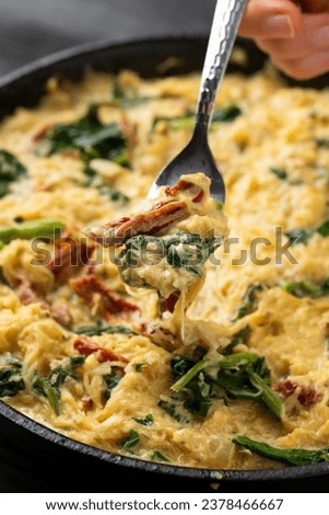 Creamy spaghetti squash pasta with parmesan cheese and sun dried tomato sauce in iron cast pan Royalty-Free Stock Photo #2378466667