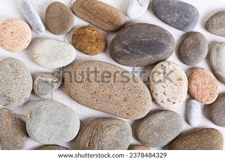 Flat lay background of smooth sea stones on a light background top view