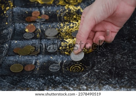 Place a coin on the Buddha's footprint for good fortune in life, Worshiping the Buddha's footprint on Koh Sichang, Landmark of Koh Sichang. Beliefs of Buddhists in Thailand. Travel on holiday. Royalty-Free Stock Photo #2378490519