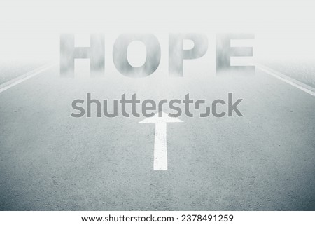 White arrow sign and hope text ahead on road goes into fog. Uncertainty and fear for the future. Unclarity ahead or negative tomorrow.