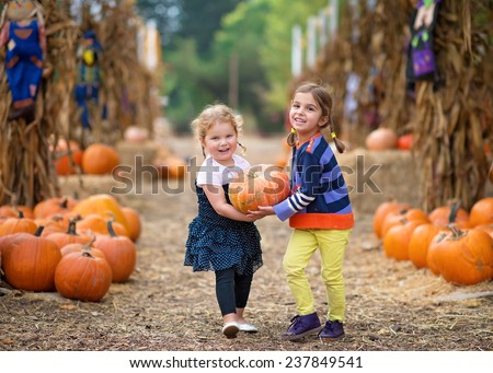 Two Girls Carrying a Pumpkin