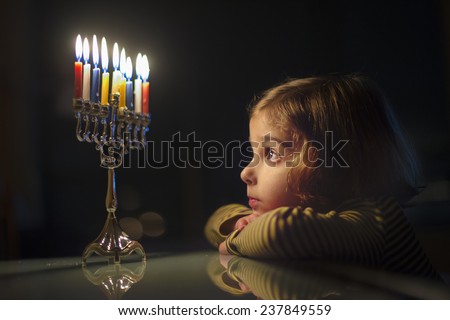 Child Looking at Menorah Candles