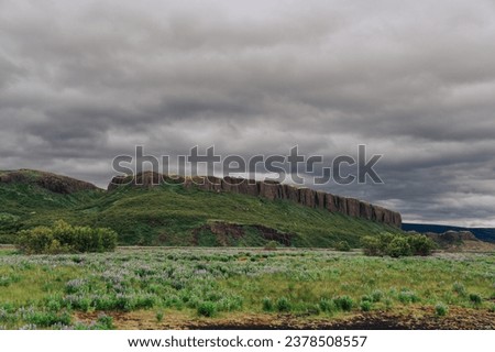 Picture of a mountain and hill in Iceland with a dramatic and stormy sky with no people. Picture of a mountain in Iceland and wild nature in Iceland with a dramatic sky.