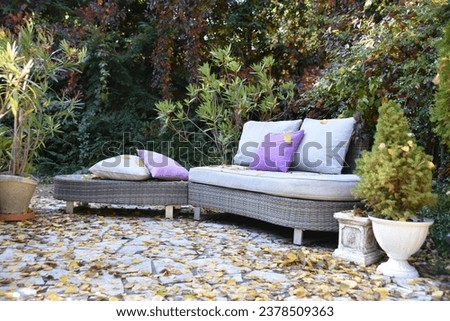 Rattan outdoor seating surrounded by foliage