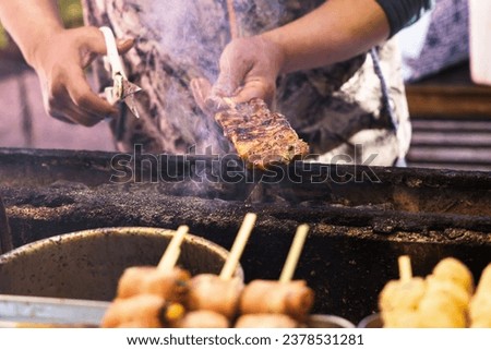 picture of a cook from a street kitchen preparing skewers of meat in Tokyo, Japan