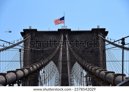 The American Flag by the Wind over Brooklyn Bridge - New York City, USA