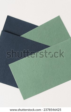 rough textured overlapping green and black crafting paper cards arranged on blank beige paper Royalty-Free Stock Photo #2378546425