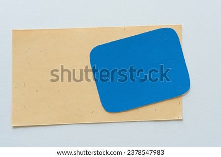 blue rectangle with rounded corners on pale yellow card and blank paper