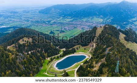 Aerial drone view turquoise lake in mountains Bavarian Alps. Ski resort in summer