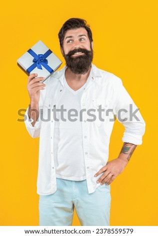 happy man with gift box in studio. man with gift box on background. photo of man with gift box.