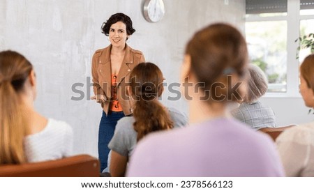 Young woman qualified lecturer speaks to small audience of listeners and talks about trends in contemporary art. Professor-student interaction, productive learning Royalty-Free Stock Photo #2378566123