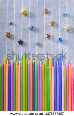 Colorful candle birthday candles on blue striped fabric background