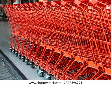 A row of red shopping carts in a modern supermarket.