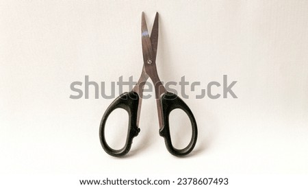 Black scissors isolated in white background. Vertical position version