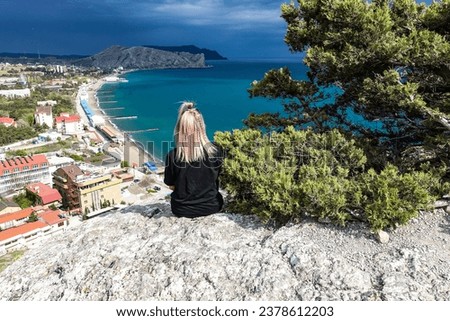 A girl on the background of a view from the Genoese fortress to the Sudak Bay. Sudak May 2021 Royalty-Free Stock Photo #2378612203