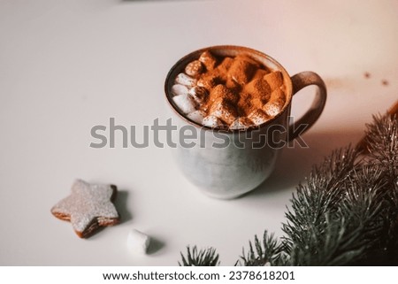 Hot cocoa with marshmallows in a Christmas atmosphere with gingerbread. Atmospheric photo, on the table a cup with cocoa, gingerbread cookies and Christmas decor Christmas tree 