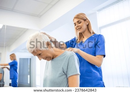 Licensed chiropractor or manual therapist doing neck stretch massage to relaxed female patient in clinic office. Young woman with whiplash or rheumatological problem getting professional doctor's help Royalty-Free Stock Photo #2378642843
