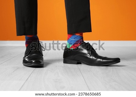 Man wearing stylish shoes and colorful socks indoors, closeup Royalty-Free Stock Photo #2378650685