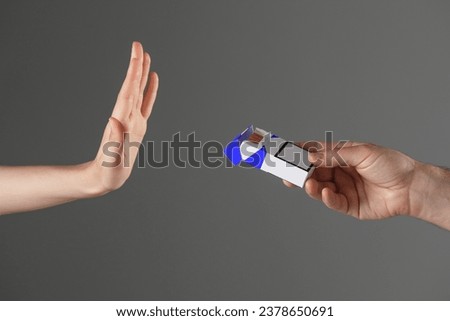 Stop smoking concept. Woman refusing cigarettes on gray background, closeup