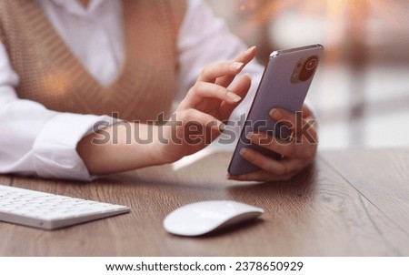 young woman in modern office browsing smartphone