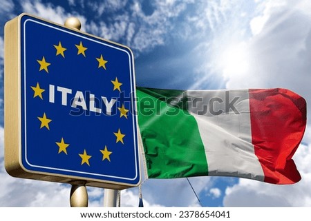 Closeup of a modern Italian border road sign with the Italian and European Union flag, against a blue sky with clouds and copy space. Schengen agreement.