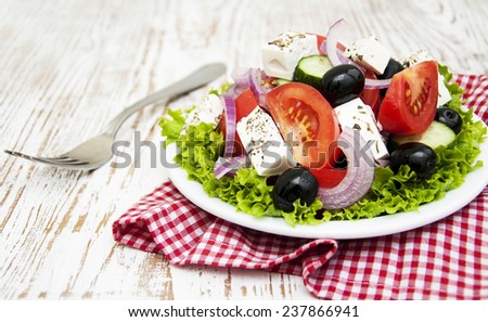 Plate with Fresh Greek salad on a wooden background