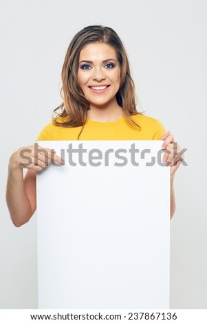 smiling woman pointing finger on white blank business card. isolated.