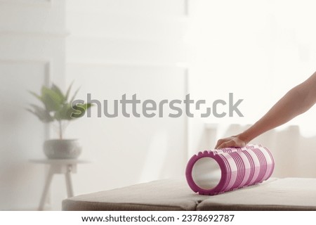 Closeup photo of athletic woman with massage roller for warming-up