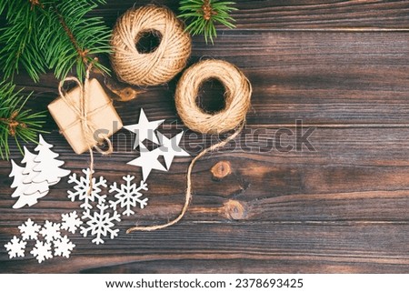 Christmas background or Holiday greeting card. christmas present box with fir tree branch and decorations on wooden table. Top view with copy space. Toned.