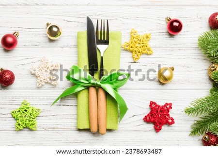 Top view of festive cutlery on new year wooden background. Close up of christmas decorations. Holiday dinner concept.